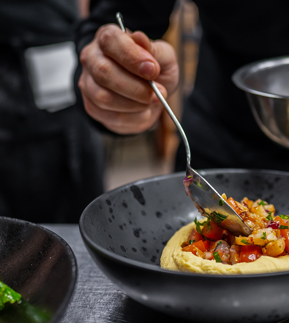 Koch richtet Essen auf Teller an | Restaurant Bad Kissingen